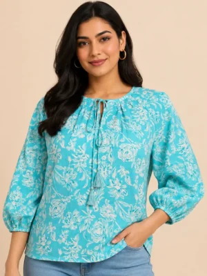 Front view of women sky blue floral printed cotton top with tie neck tassel detail